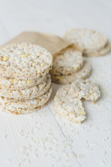 Stacked of puffed rice with grains on white wooden table