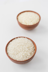 Fototapeta na wymiar Close-up of raw jasmine rice bowls on white wallpaper