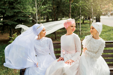 Fototapeta na wymiar three beautiful young women in festive muslim dresses