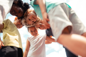 Group of children talking leaning forward to each other.