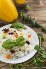 Fresh tasty vegetarian rice on plate with basil leaves and parsley