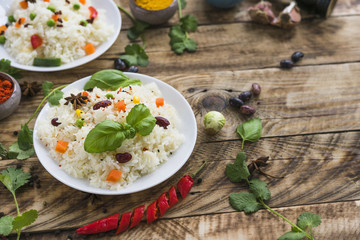 Beans rice and basil leaves on plate with organic ingredients on table