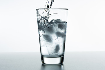 Beautiful splash of water in a glass with ice