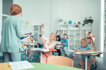 School children doing sums with their maths teacher.