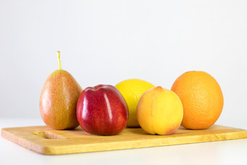 red apple, pear, lemon, orange, peach on white background, copy space