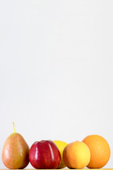 red apple, pear, lemon, orange, peach on white background, copy space