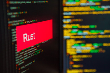 Programming language, Rust inscription on the background of computer code.