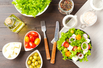 Greek salad with feta on wooden background