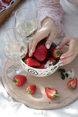 champagne and strawberries, female hands.