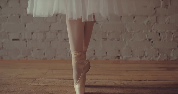 Dancer in pointes trains the movements of the legs and arms. Span camera bottom up.