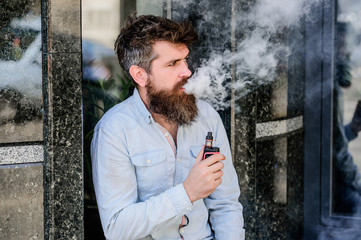 habits concept. man smoking e-cigarette. hipster man hold vaping device. Mature hipster with beard. Health safety and addiction. inhaling vapor. Bearded brutal male smoking electronic cigarette