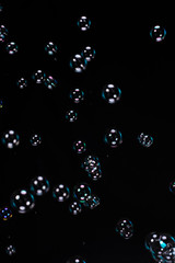 Black background with colorful soap water bubbles, balls or spheres