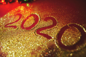 Festive figure 2020, written on a claret background with sparkles. New Year's concept