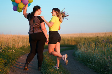 Two young best friends walking down a country road with flowers and balloons. friendship, party,...