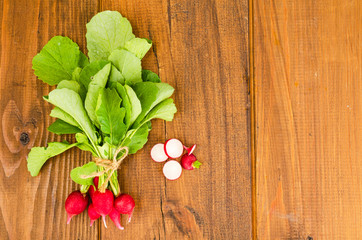 Bunch of fresh radish on brown wooden table. 