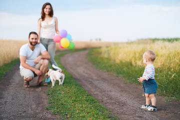 Happy family portrait. Mother, father, son and their dog enjoy time together playing outdoors. People and pets, lifestyle concept