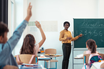 Dark-skinned teacher giving the question for her smart pupils