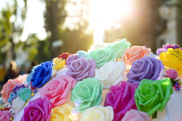 Artificial flowers of different colors close up at sunset