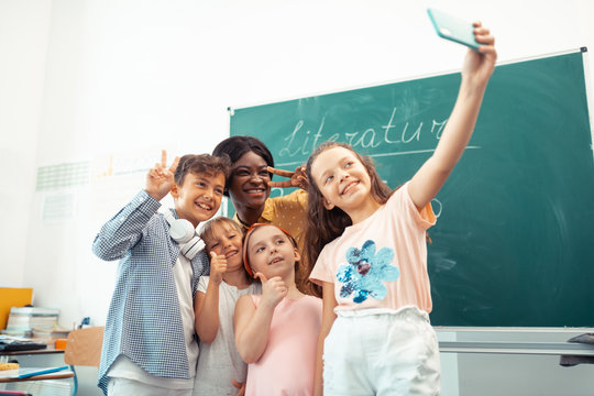 Teacher and children feeling happy while making selfie together