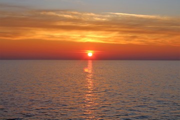 evocative image of sunrise over the sea with the sun rising over the horizon