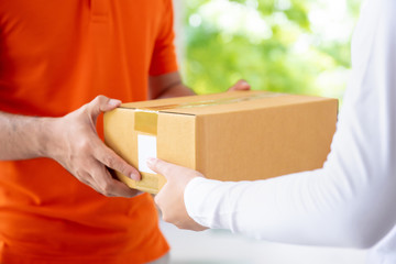 Courier service delivery man giving parcel box to customer
