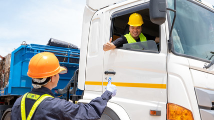 Foreman with safety hats and safety vest is carrying a car inspection document in the parking with truck drivers,Concept of planning work day. © visoot