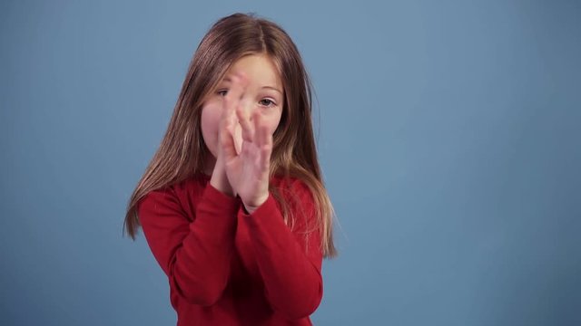 Fun, pretty caucasian girl in red sweater, fooling, looking at camera, inflate cheeks, isolated over pastel blue background in studio. People sincere emotions lifestyle concept