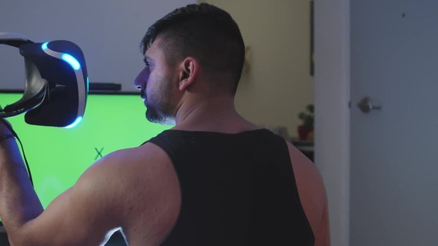 Man Puts Virtual Reality Googles on Head and Raises Gun for Battle, Green Screen