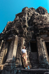 Fototapeta premium Young female tourist traveler is posing at Angkor Wat temple, Siem Reap, Cambodia