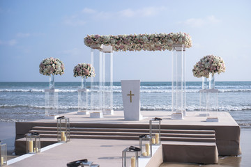 Wedding decoration on the background of the ocean in a tropical country. Romantic theme with beautiful sea views. Pastor scene with a cross