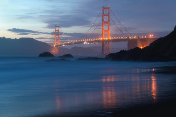 Classic panoramic view of famous Golden Gate Bridge seen from scenic Baker Beach in beautiful golden evening light on adusk with blue sky and clouds in summer, San Francisco, California, USA