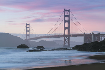 Classic panoramic view of famous Golden Gate Bridge seen from scenic Baker Beach in beautiful golden evening light on sunset with blue sky and clouds in summer, San Francisco, California, USA