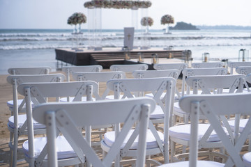 White chairs stand on the seashore in rows and the scene ahead. Outdoor conference. Religious meeting of the church for the wedding. Stock photo