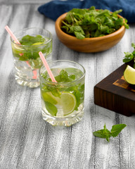 Cool lemonade with mint and lime and ice in glass cups