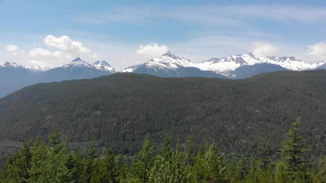 Flying over the trees towards the mountains in B.C, Canada