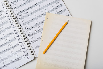 Pencil and mpty pages on sheet music