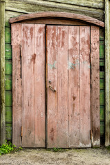 Old wooden door with the wooden carved architrave