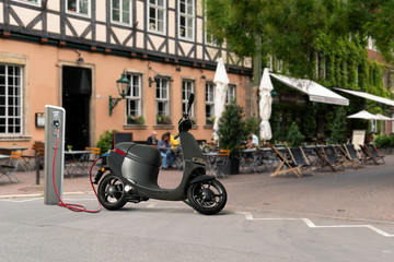 Electric scooter for sharing with charging station on a city street