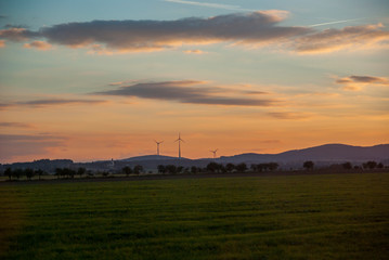 Silhouette of wind turbines at sunset. The concept of alternative energy.