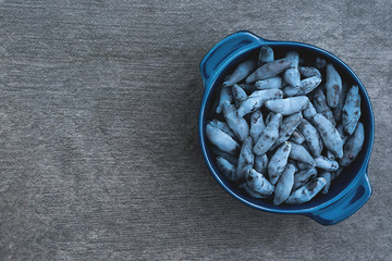 Honeysuckle berries in a bowl on stone gray garden table background.