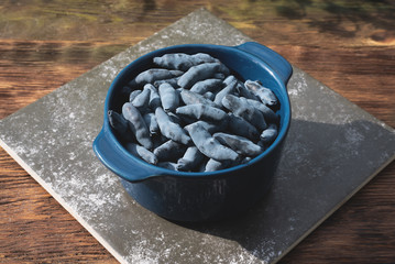 Honeysuckle berries in a bowl on garden table.