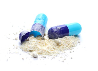 Blue pills, open capsules with medicine isolated on white background