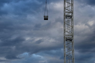 Dunkle düstere Gewitterwolken vor einer Baustelle mit einem Baukran