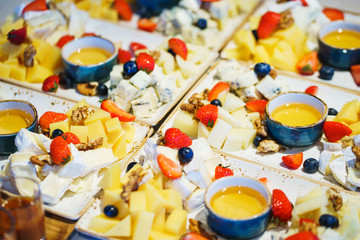 Slices of different cheese plate berries and honey. 