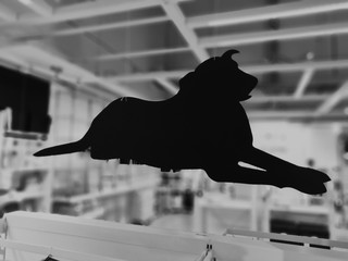 Black and white cardboard dog silhouette with blurred background