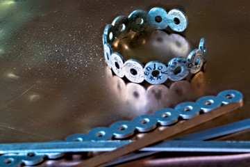 Close up shot of metal handmade bracelet and equipments on copper surface.
