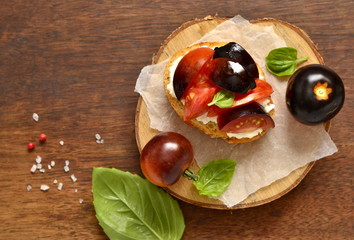 Bruschetta with soft cheese, tomatoes and basil, view from above, copy space