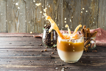 Cold creamy horchata coffee, with coffee beans and spices, wooden background copy space