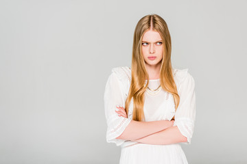 angry girl with crossed arms isolated on grey