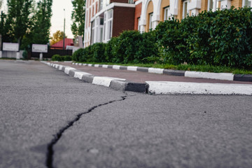 a long crack on asphalt leading to the curb